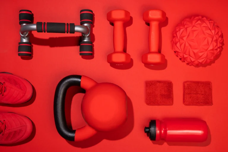 Sports equipment and gear on a red background symbolizing cooperation with the fitness and health industry.
