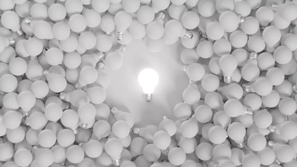 Bright lit bulb among unlit bulbs, symbolizing strong and unique value proposition ideas.
